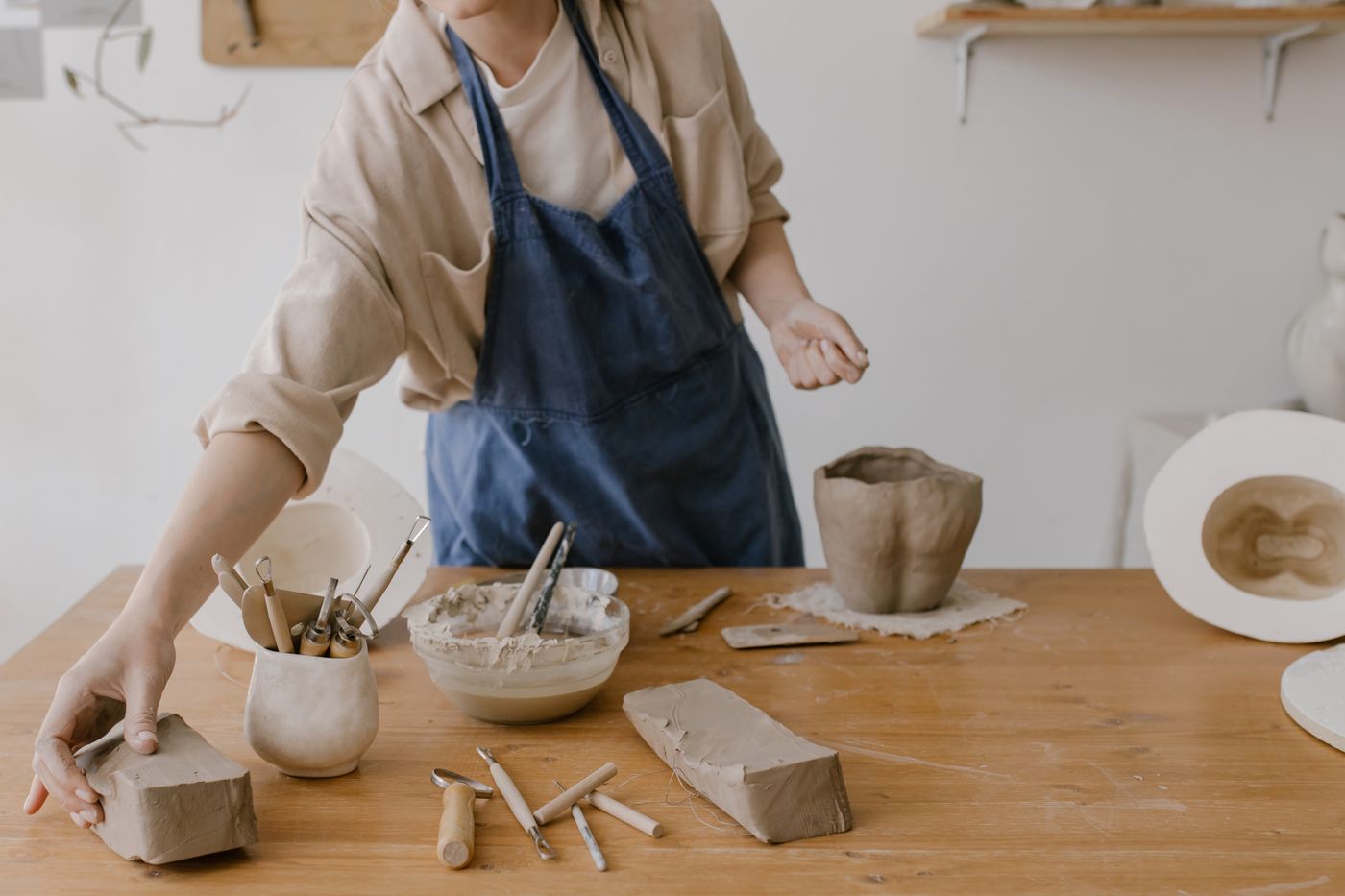 A craftsperson working with clay in a pottery studio